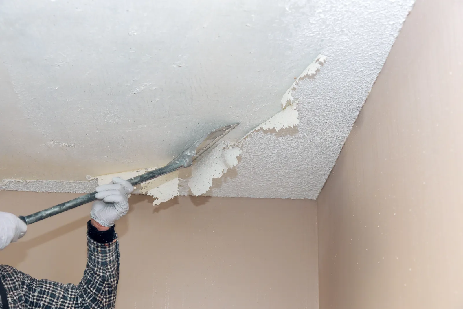 The popcorn ceiling removal process involves preparing the room